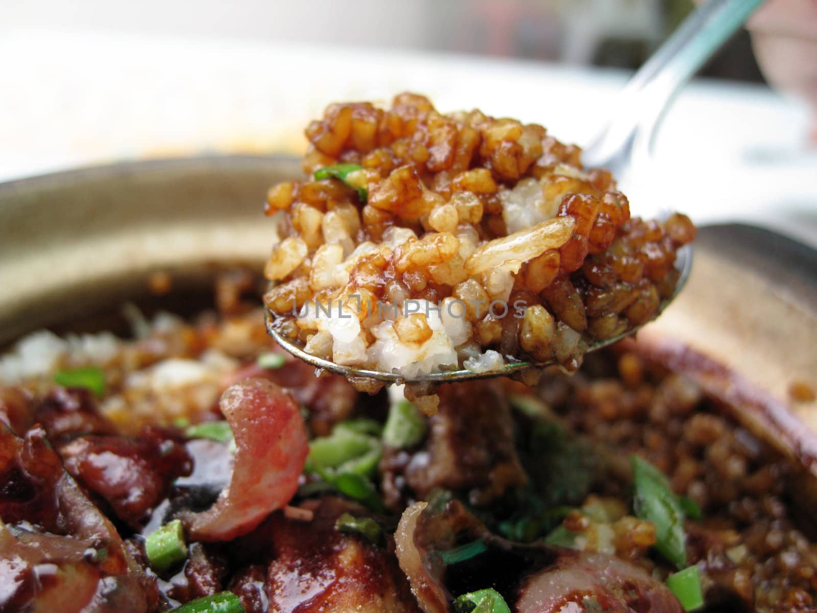 a scoop of rice with delicious soya sauce