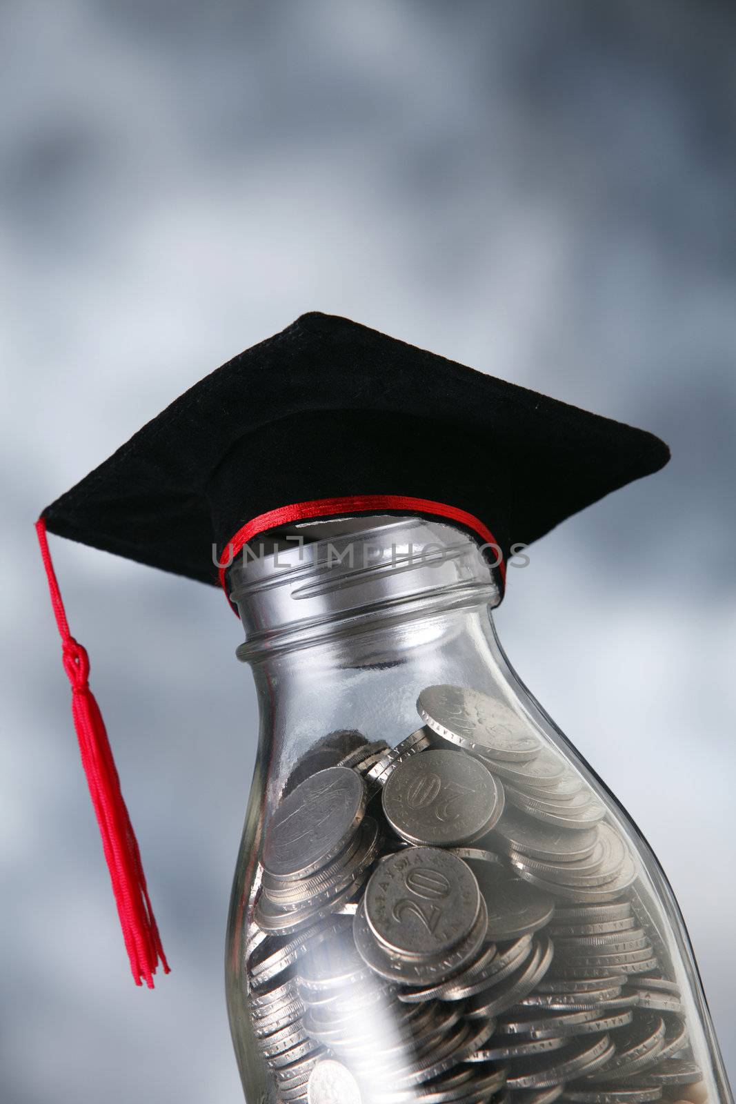 Bottle of cash with graduation cap.