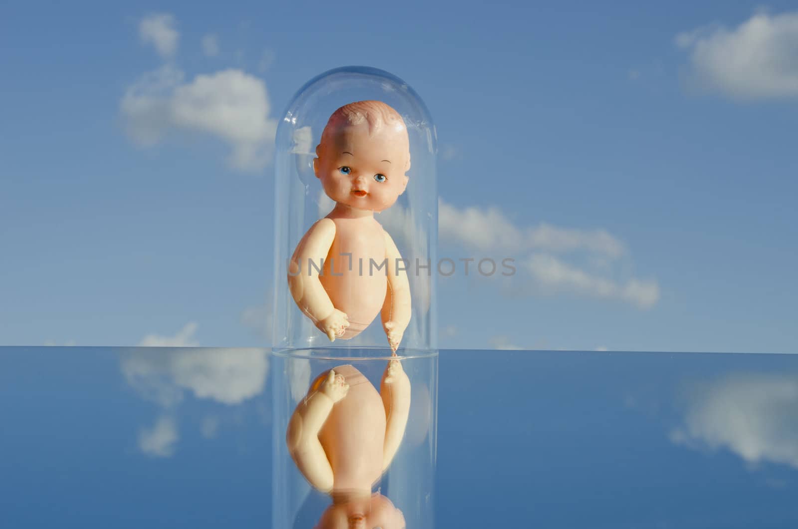 vintage dolls torso on mirror and sky clouds