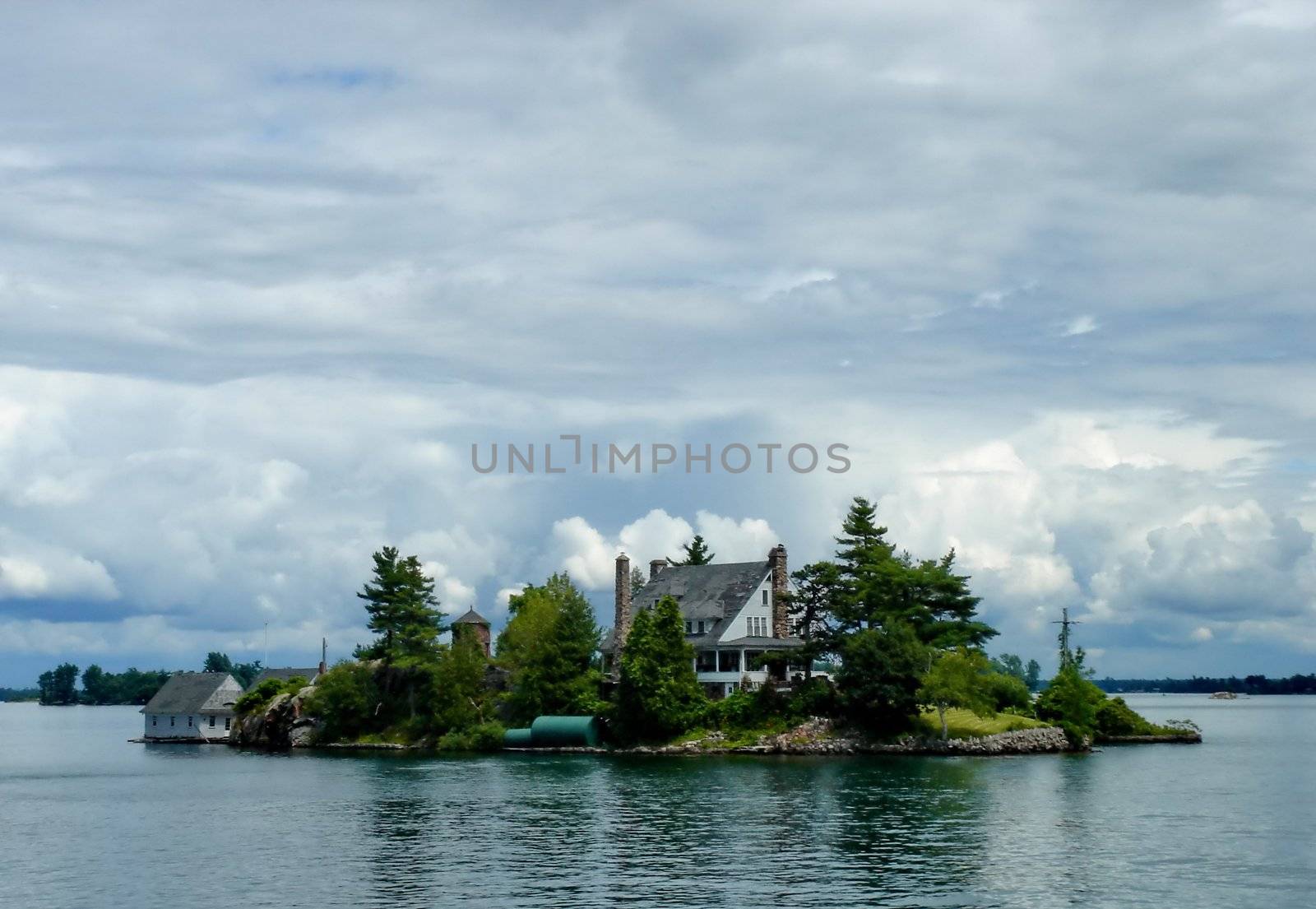 Zavikon island on Ontario Lake with a house in the middle of thousand islands on Ontario lake, Canada, by cloudy weather