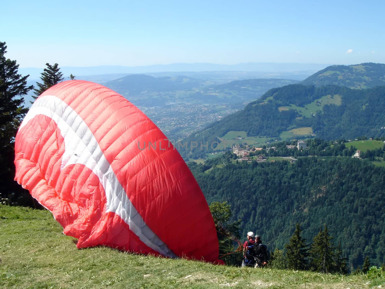 Paraglider at the top of the mountain ready to go flying by beautiful summer day