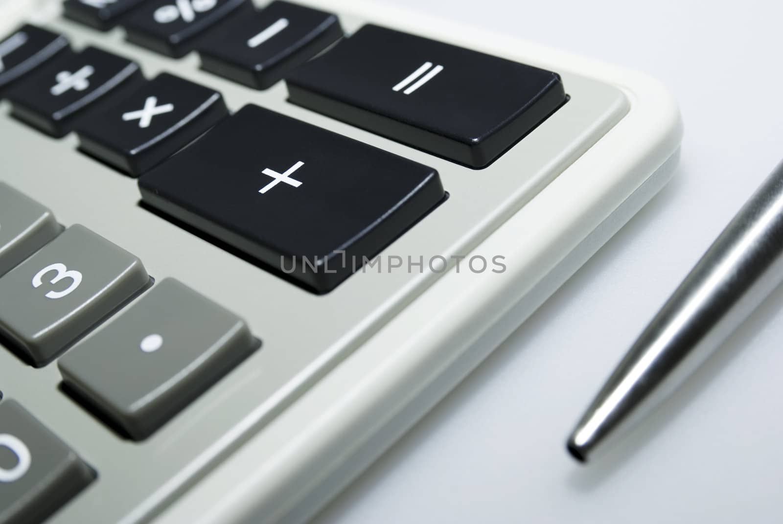 Calculator and pen on white background.