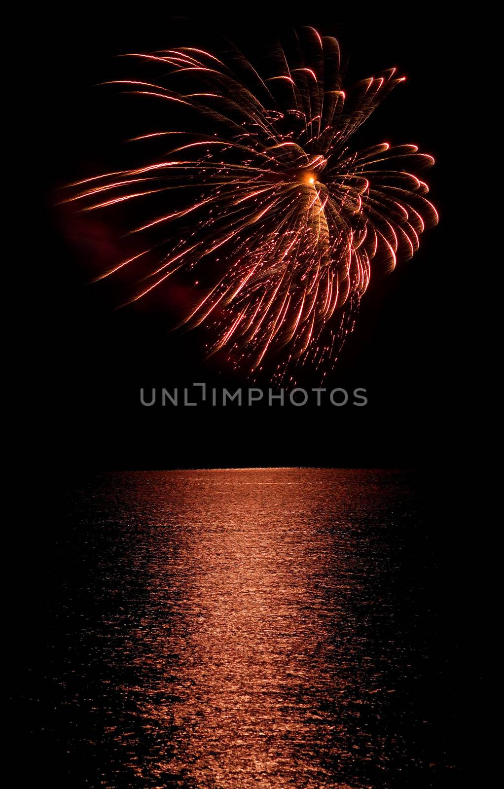 Long Exposure of Fireworks Reflecting on Calm Rippling Water