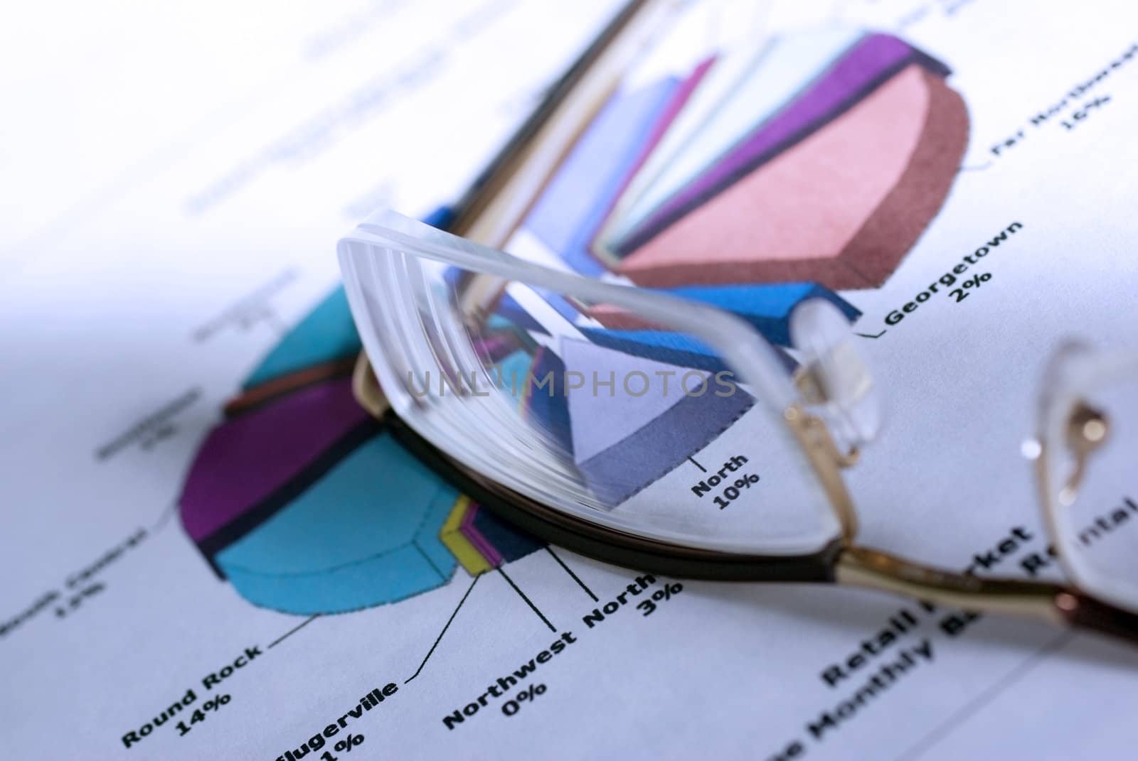 Glasses laying on color diagramm. Financial Concept. Cold photo  by borodaev