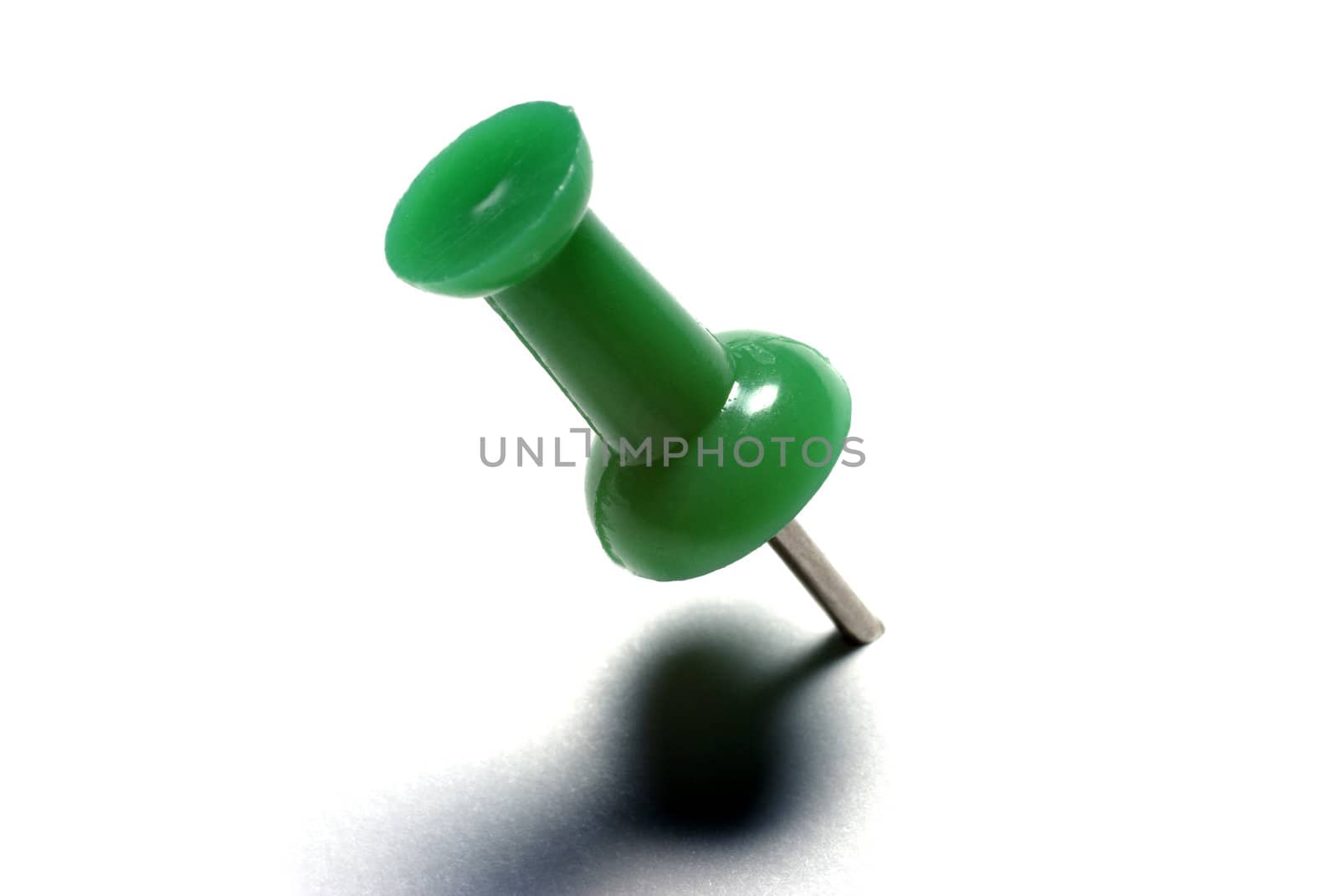 Macro of green drawing pin isolated on white background. by borodaev