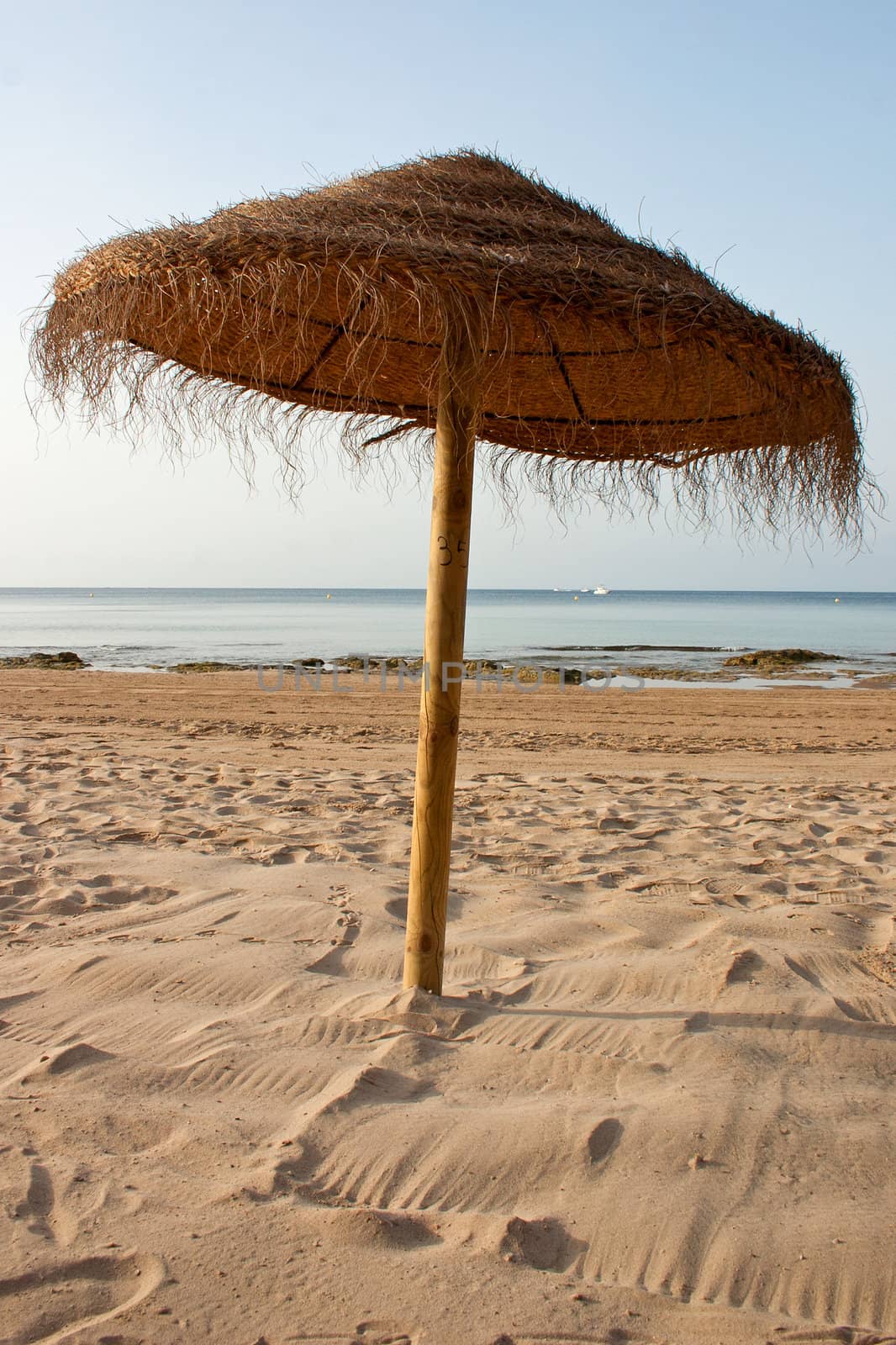Brown Parasol at the beach made out of straw 