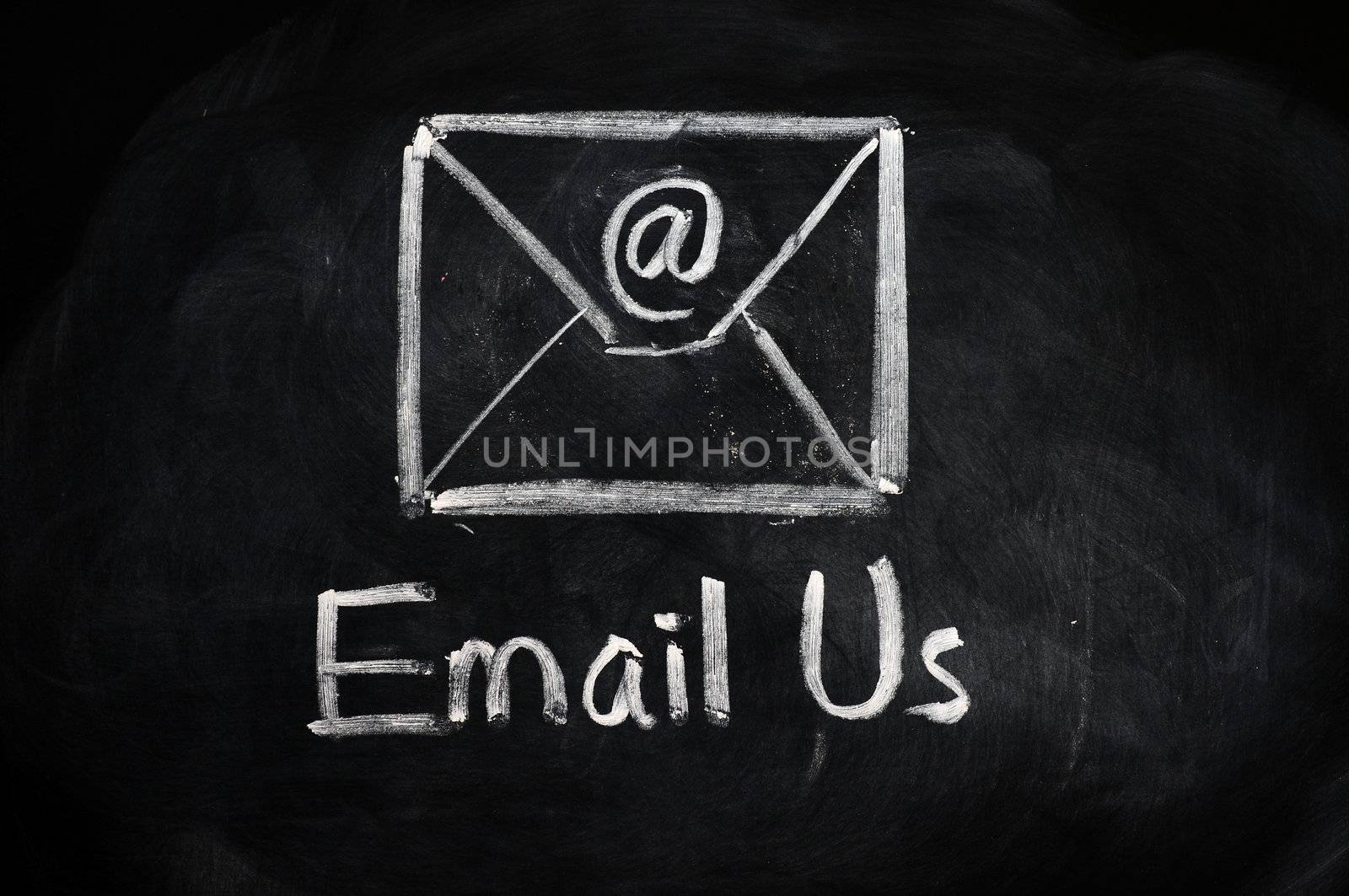 Email us concept with an internet symbol and envelope drawn with chalk on blackboard