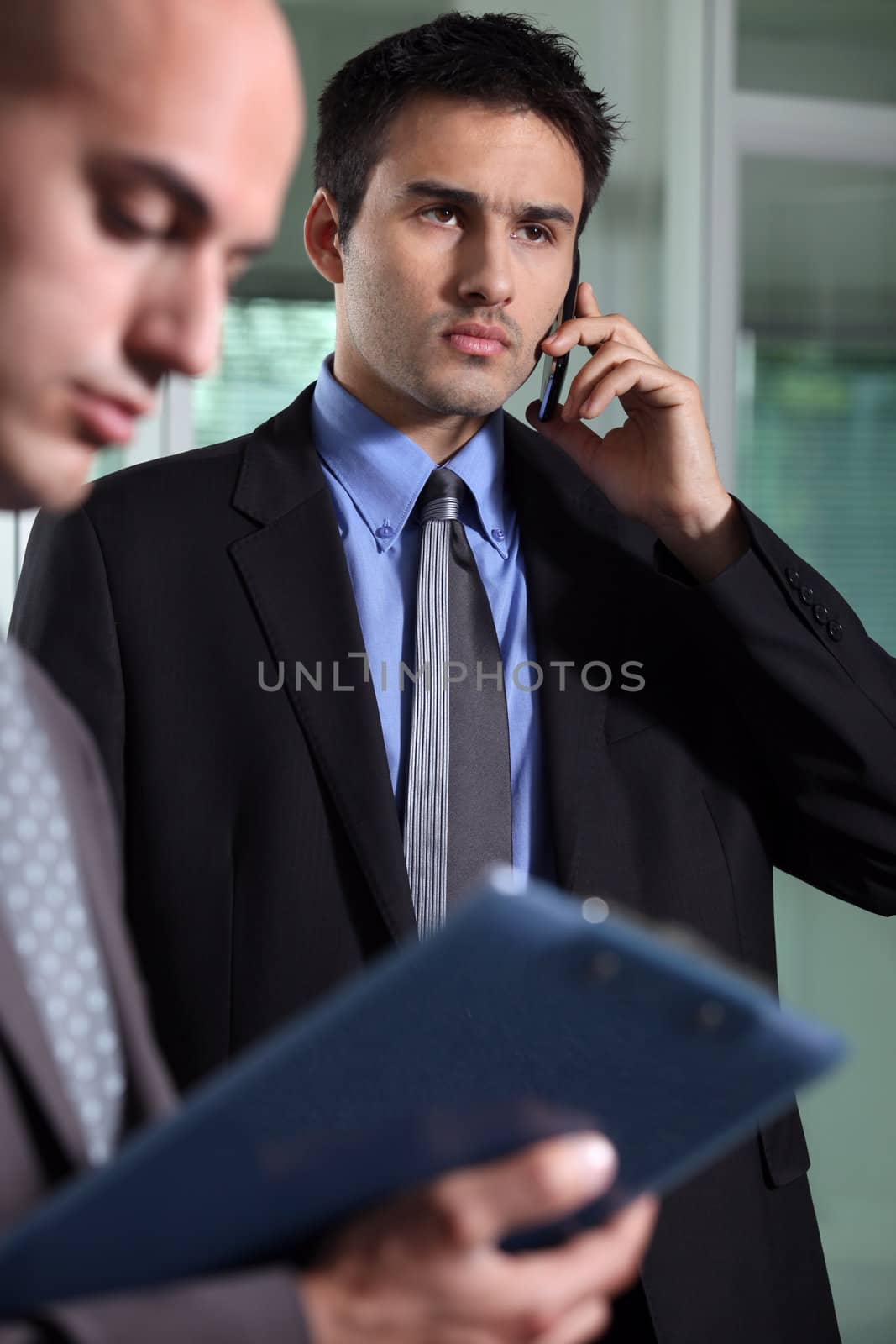 Serious businessman on the phone by phovoir