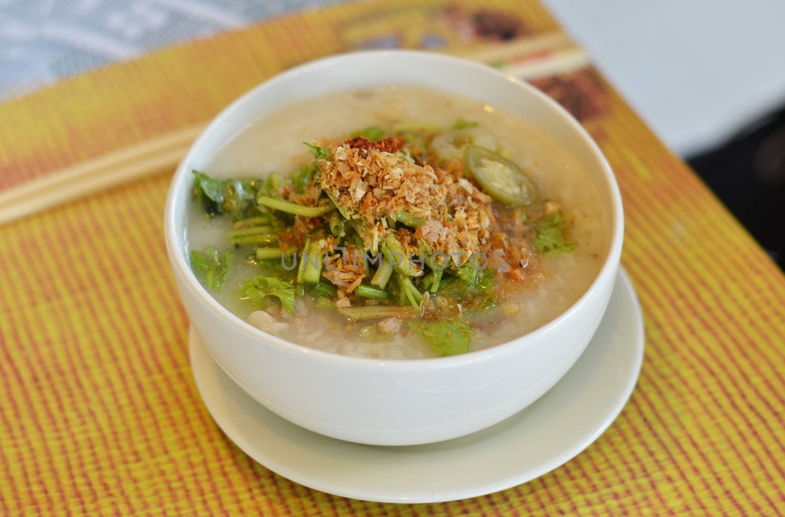 asian style rice soup with herbs in a bowl