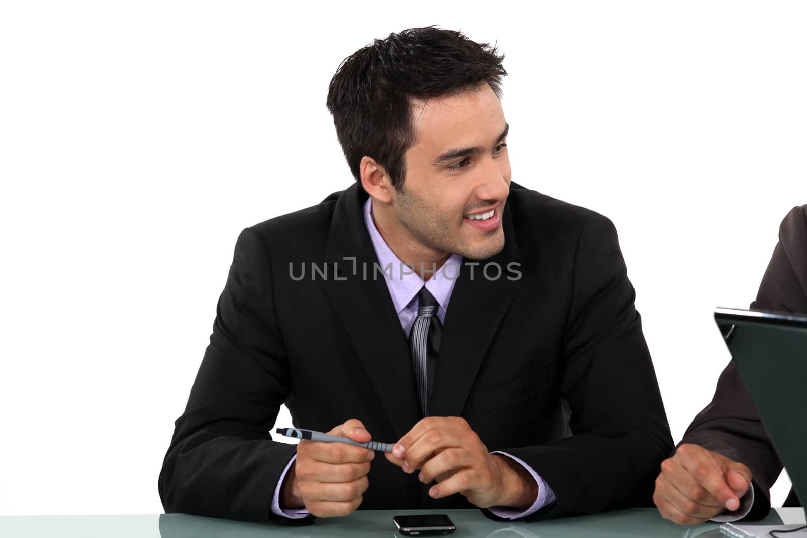 Smart businessman sitting at a desk by phovoir