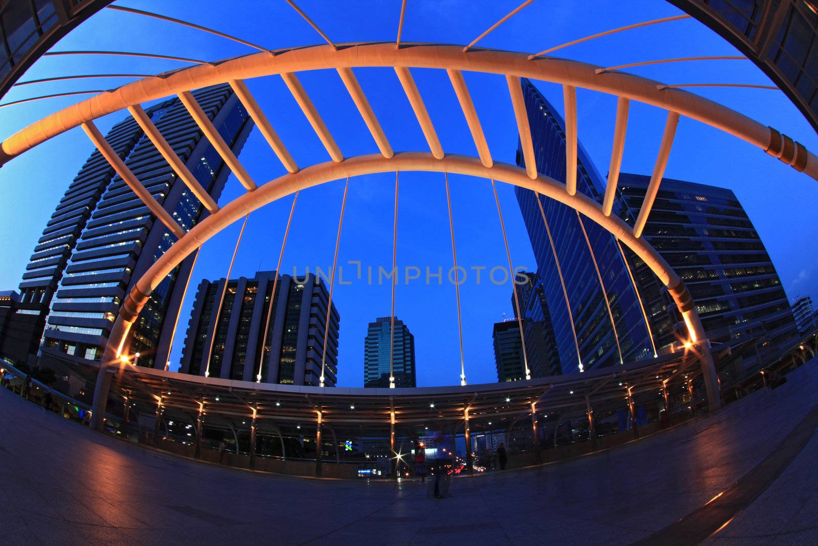Bangkok pubic skywalk in business district downtown cityscape at night, fish eye perspective