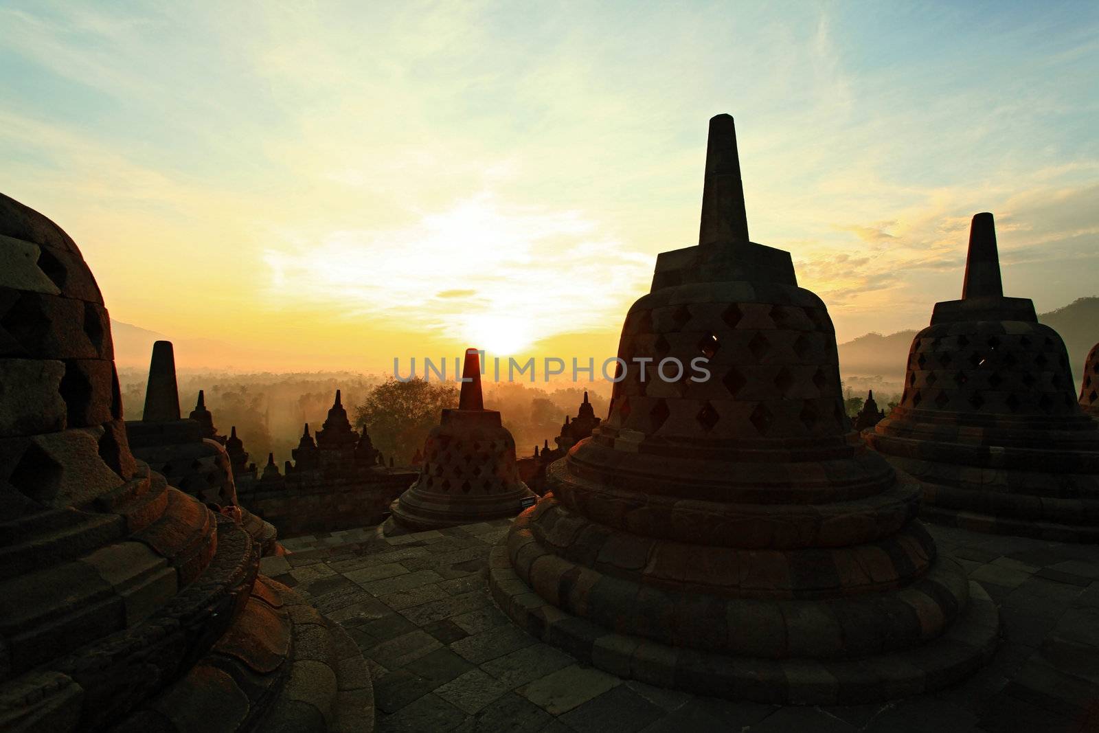 Silhouette of Ancient stupa Borobudur Temple, with sunrise in Yogyakarta, Java, Indonesia.
