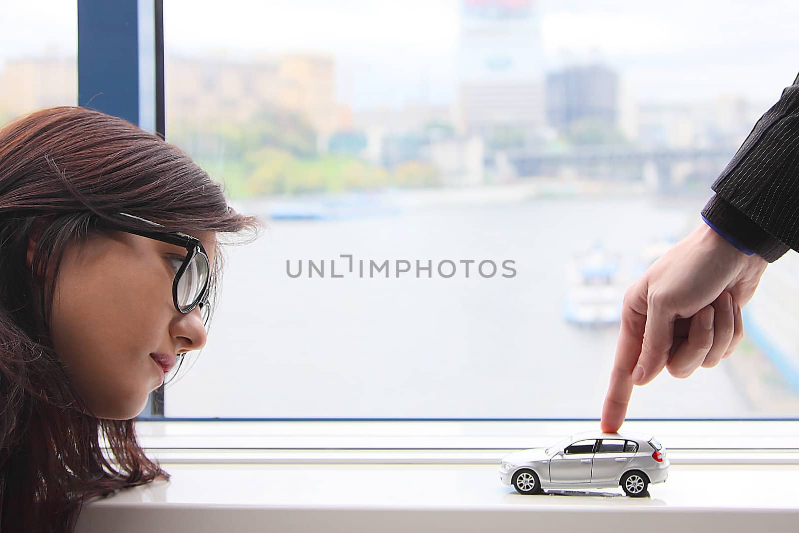 The finger of the businessman moves the toy car