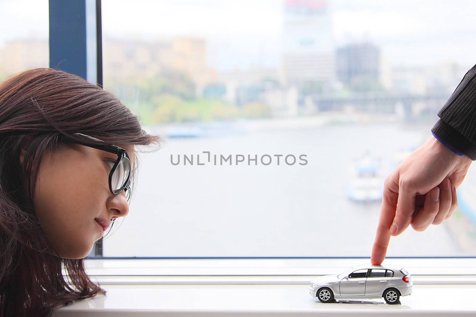 The finger of the businessman moves the toy car