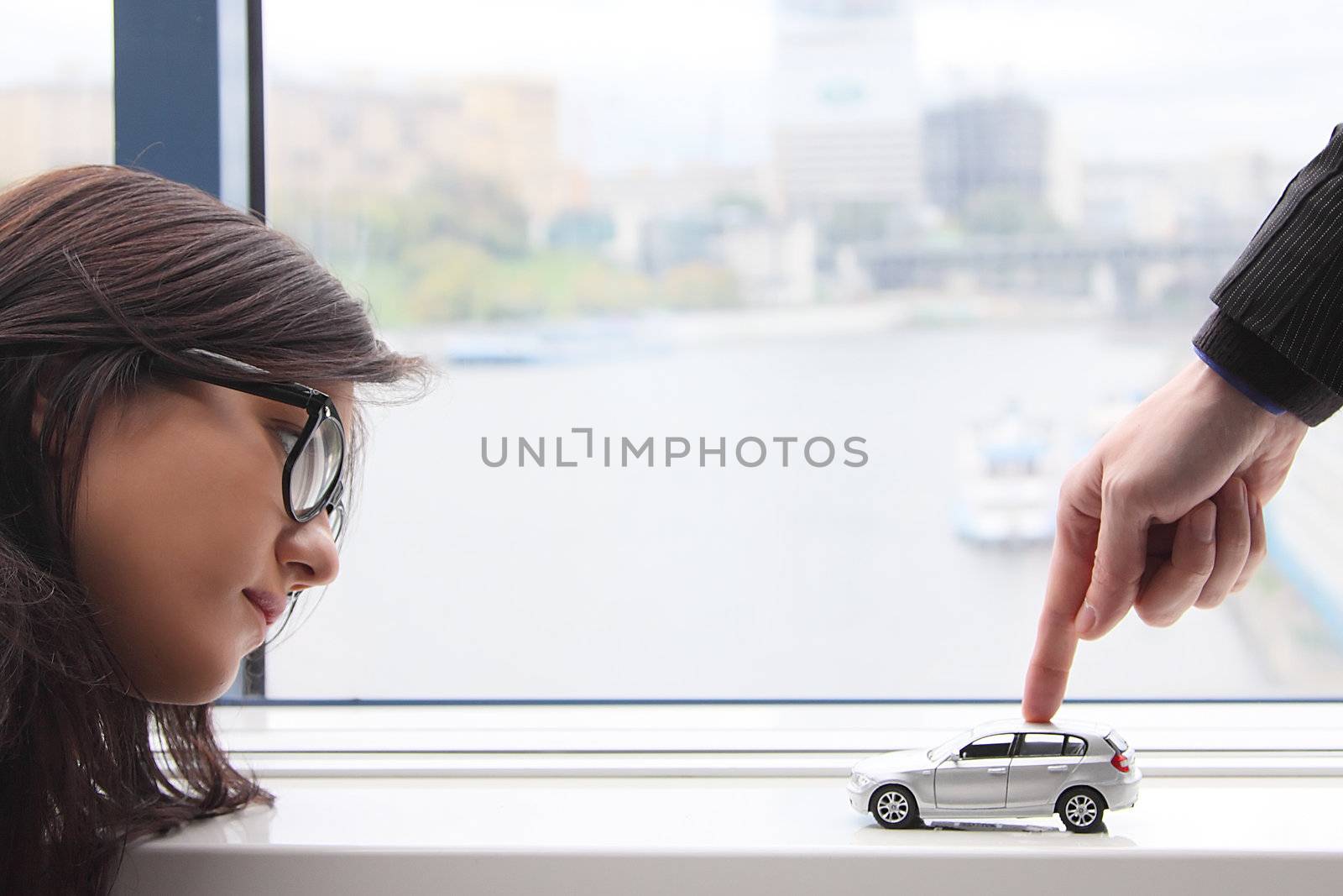 The finger of the businessman moves the toy car