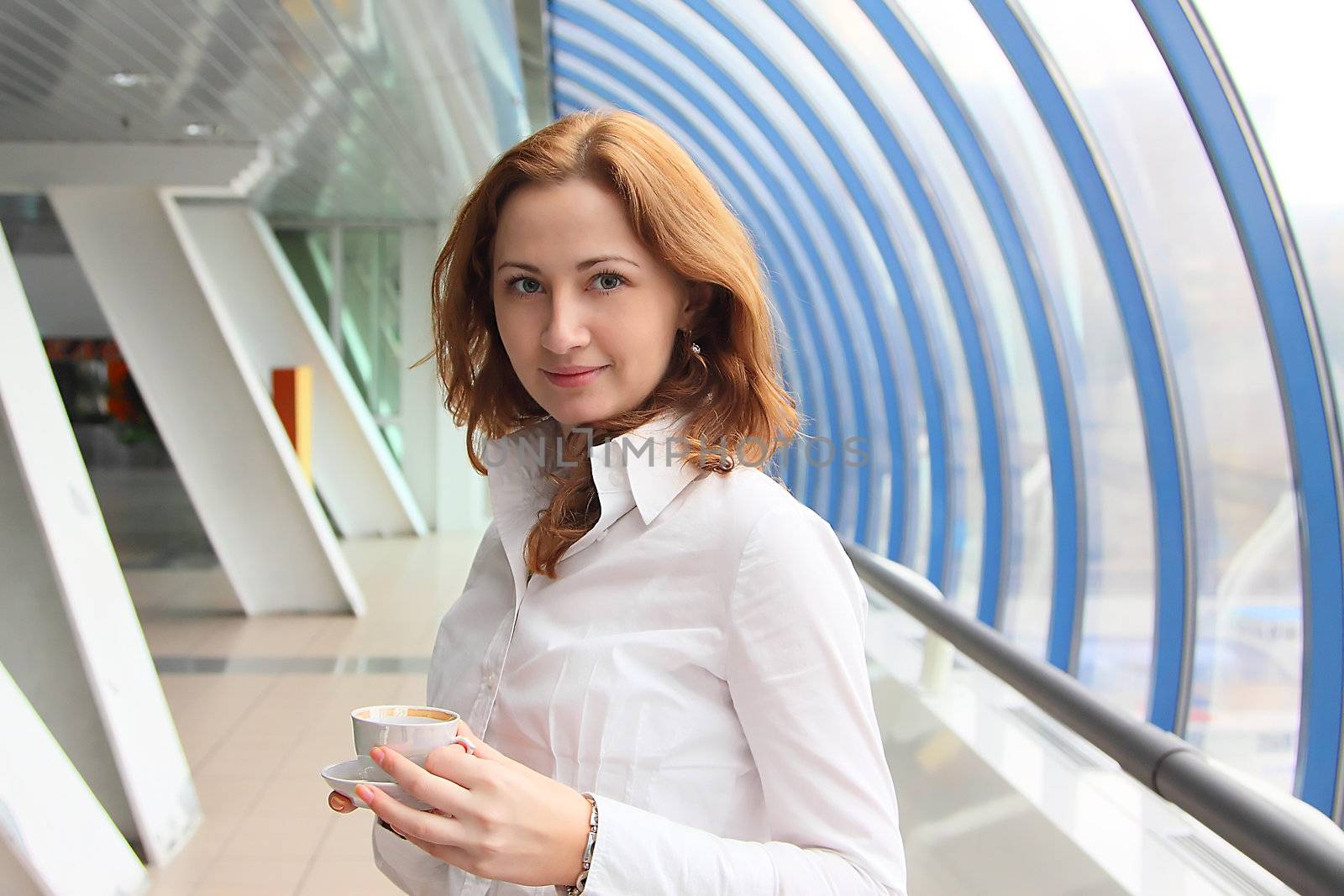 The businessman drinks coffee at office from a small white cup