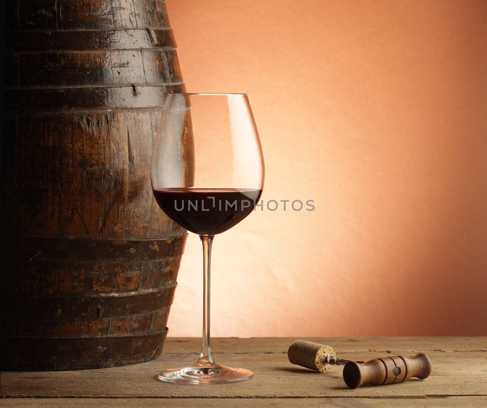 red wine glass, woodden barrel and corkscrew