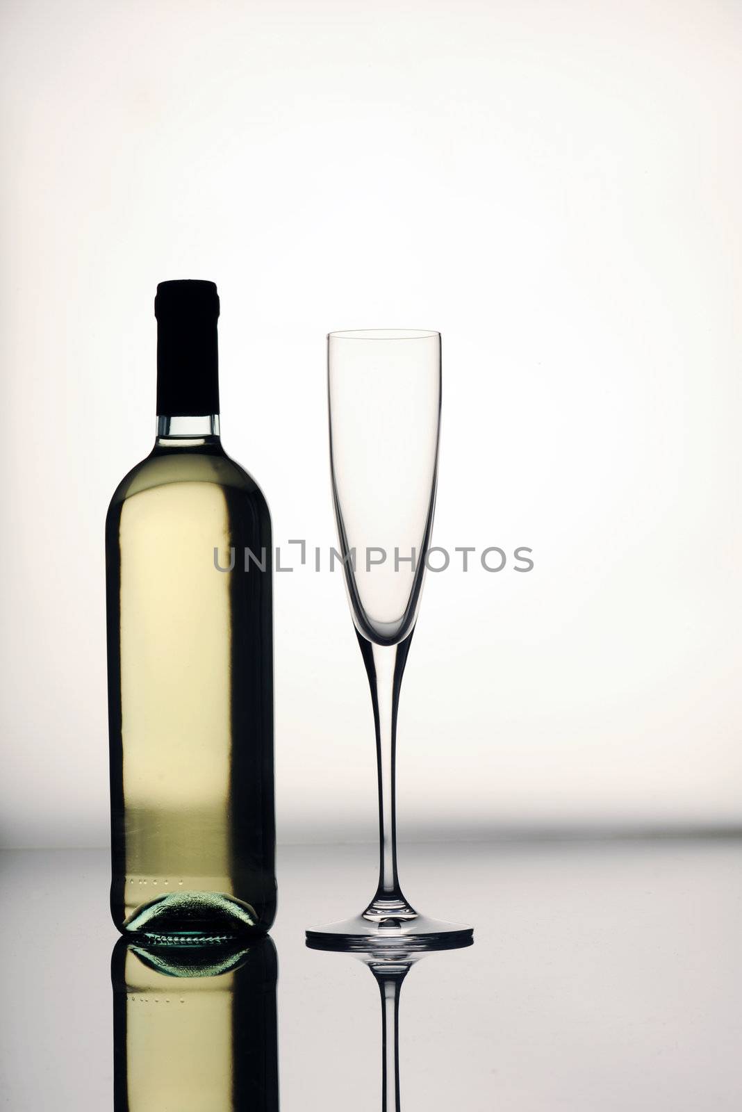 bottle and glass on a reflective surface