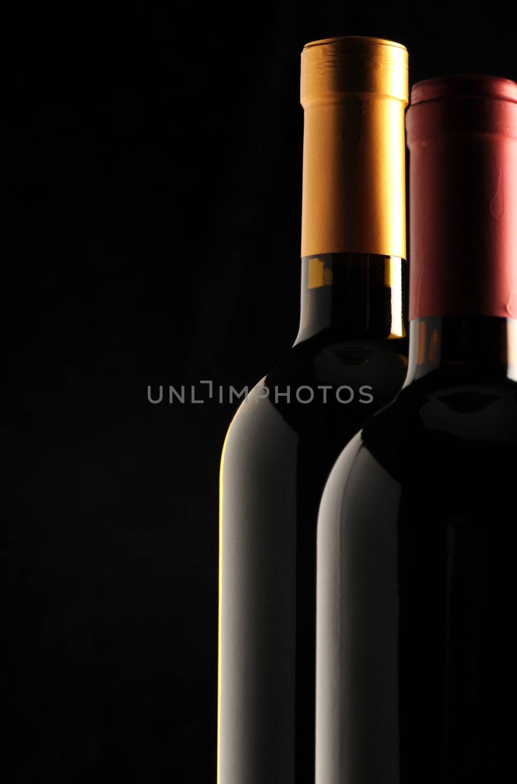 bottles of red and white wine on black background