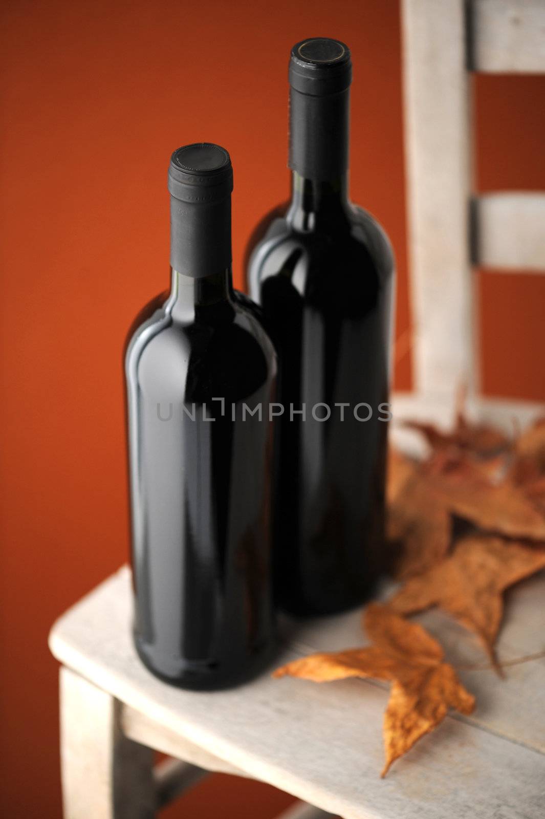  bottles of red wine on a white wooden chair (shallow dof)