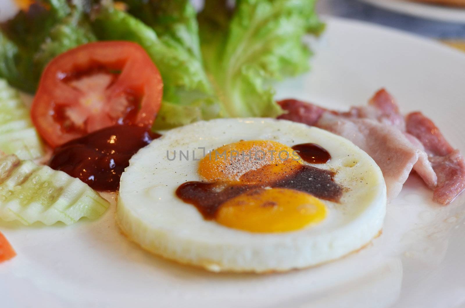 american style breakfast , with bacon, fried egg and fresh vegetables