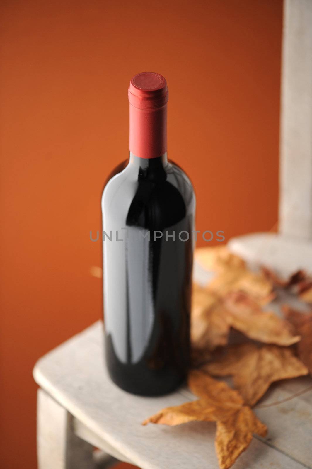 red wine bottle on a white wooden chair