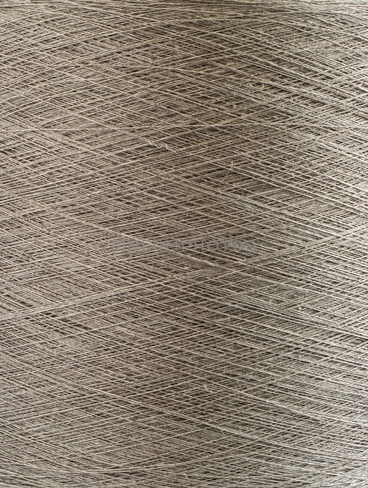 Natural linen yarn bobbin closeup detail as background