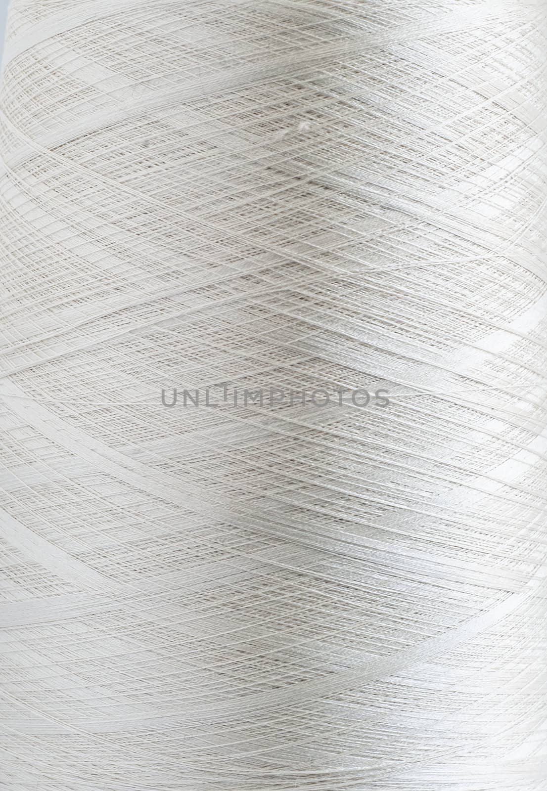 White silk yarn bobbin closeup detail as background