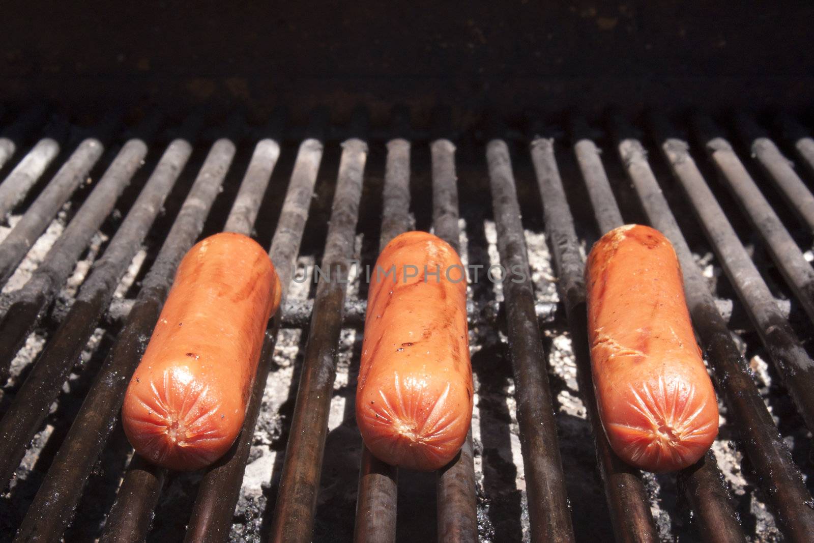 BBQ hot dogs on the grill in the summer.