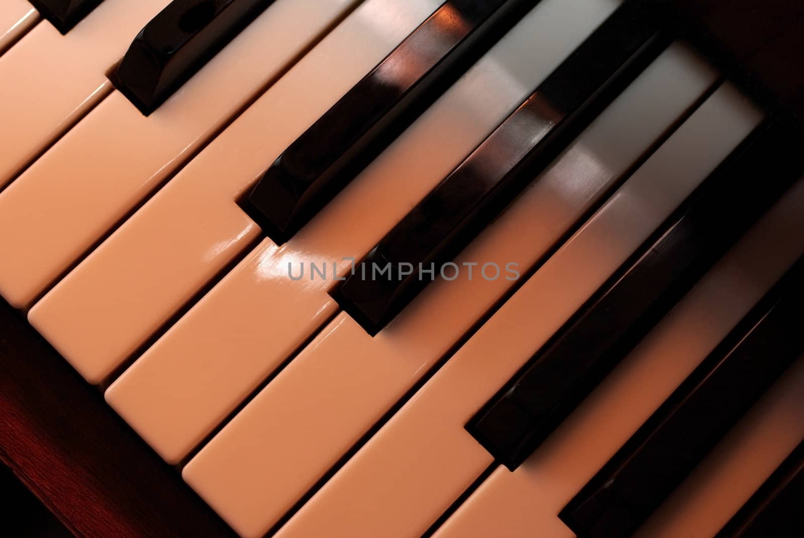 Piano keys close up using warm photo filter. Playing with light. by borodaev