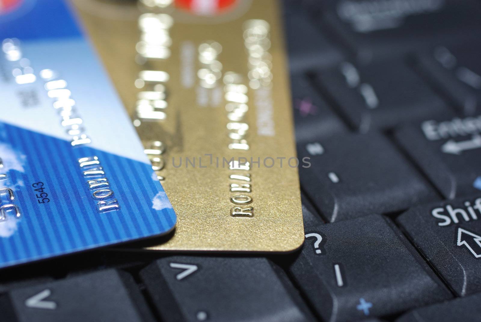 Credit cards laying on laptop's keyboard.