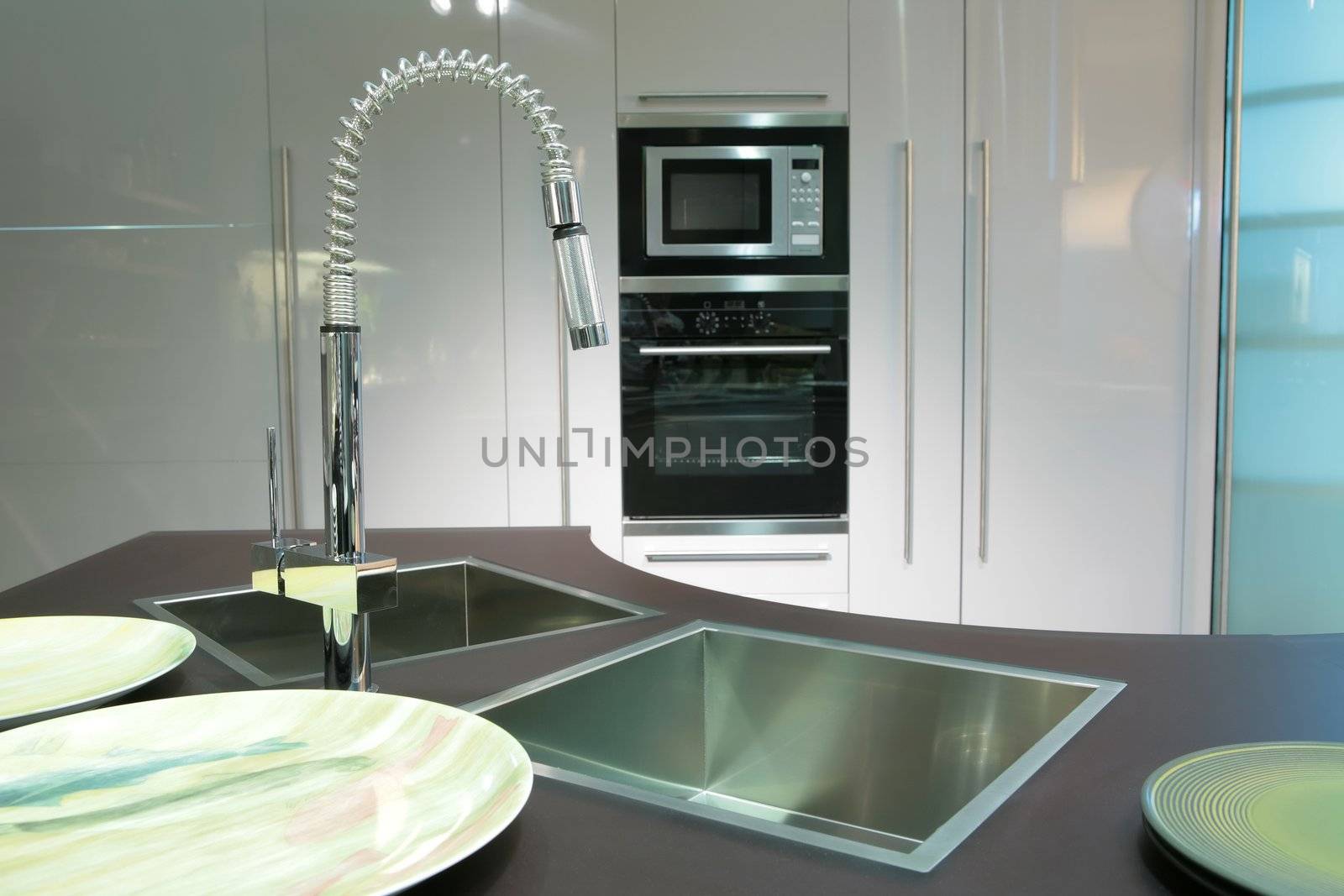 modern metallic sink with graceful tap and plate on the super-modern kitchen