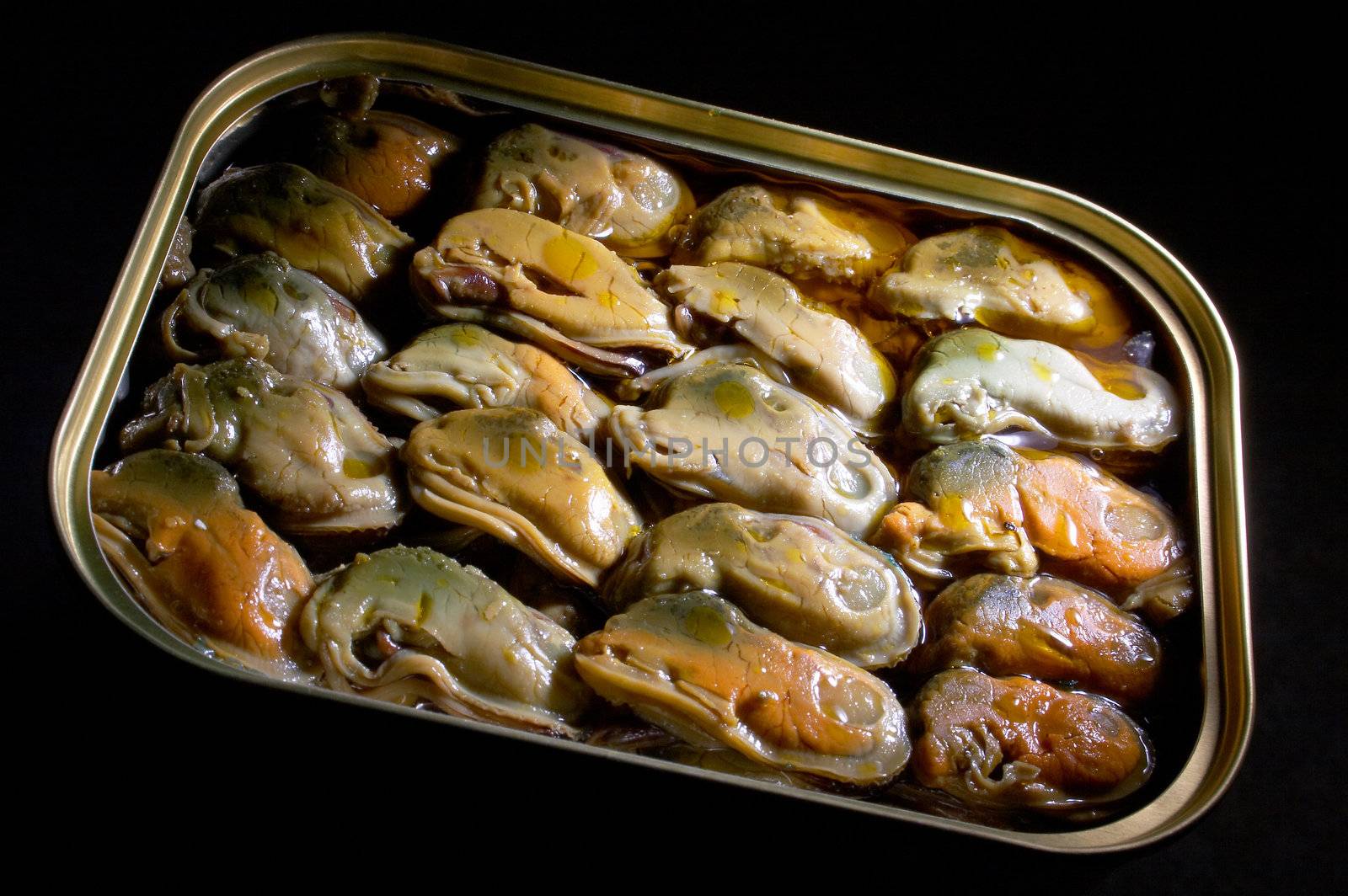 Smoked mussels in vegetable oil on a black background