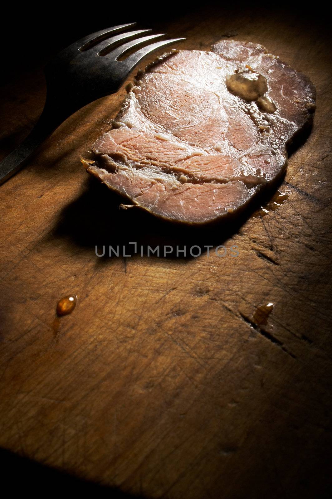 Cold boiled pork and fork on a wooden table