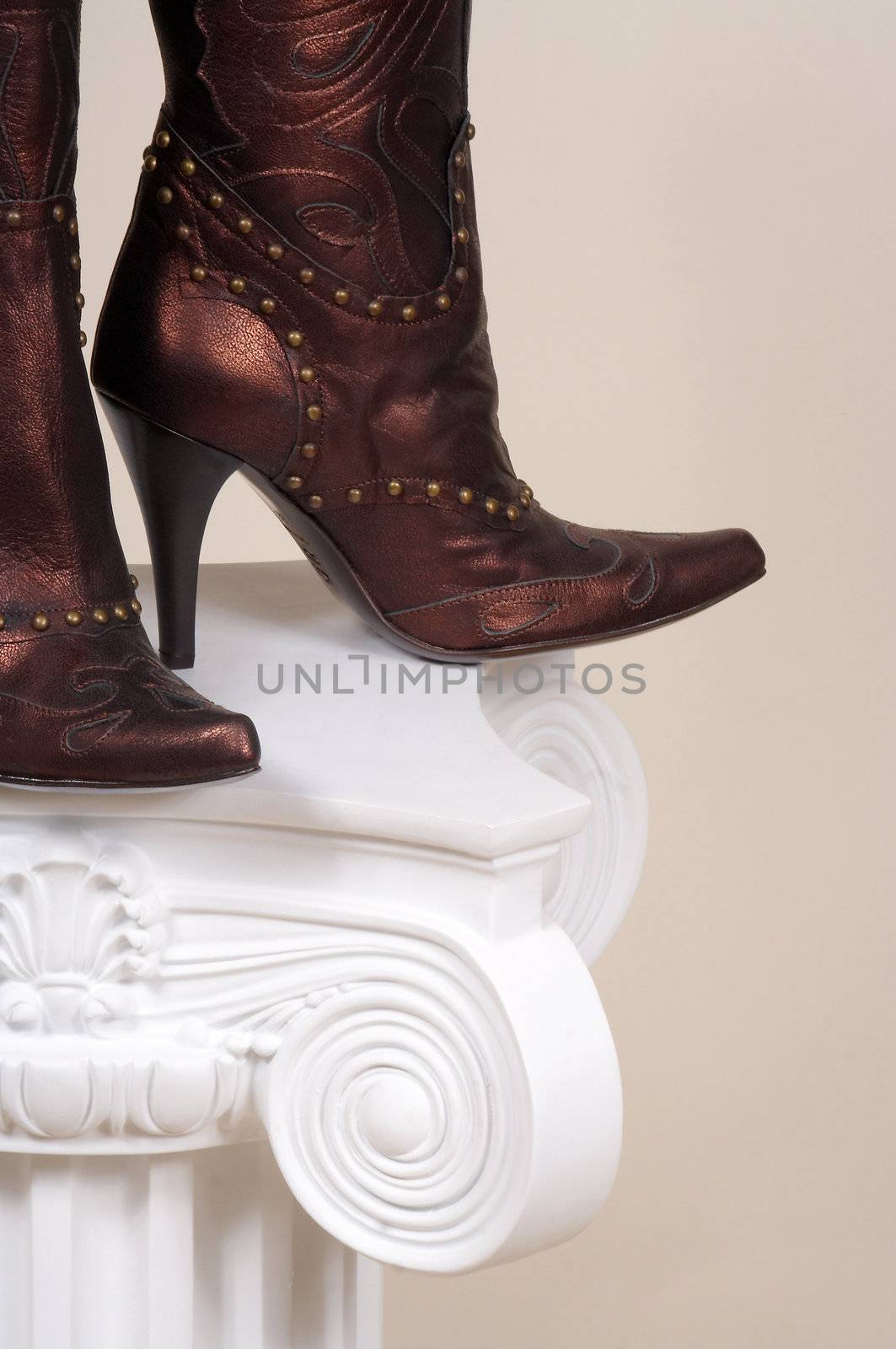 Leather female boots on a white podium