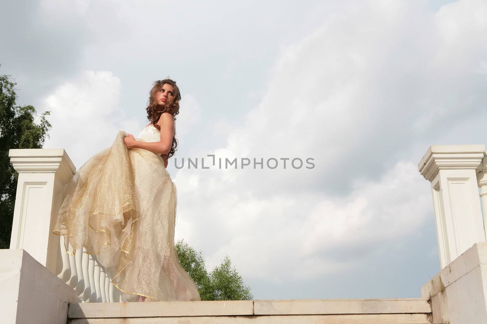 retro style  portrait of the beautiful girl in white gown on background cloudy sky