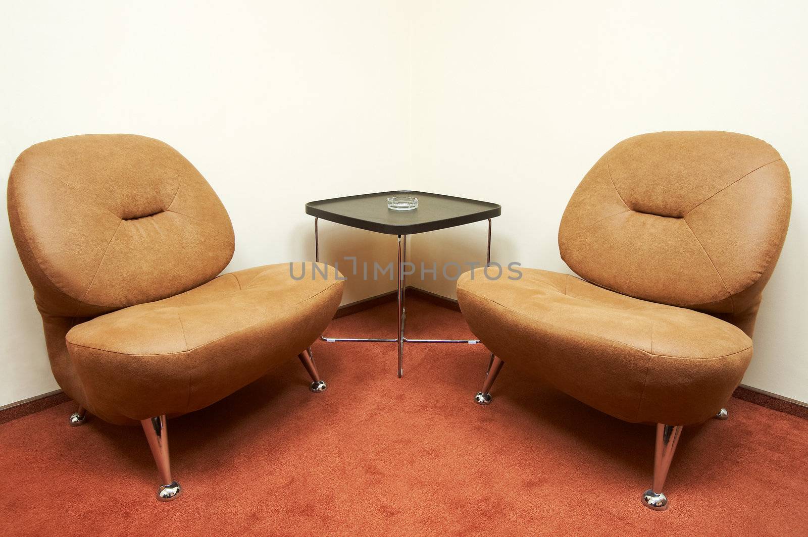 Two leather armchairs and ashtray on a table