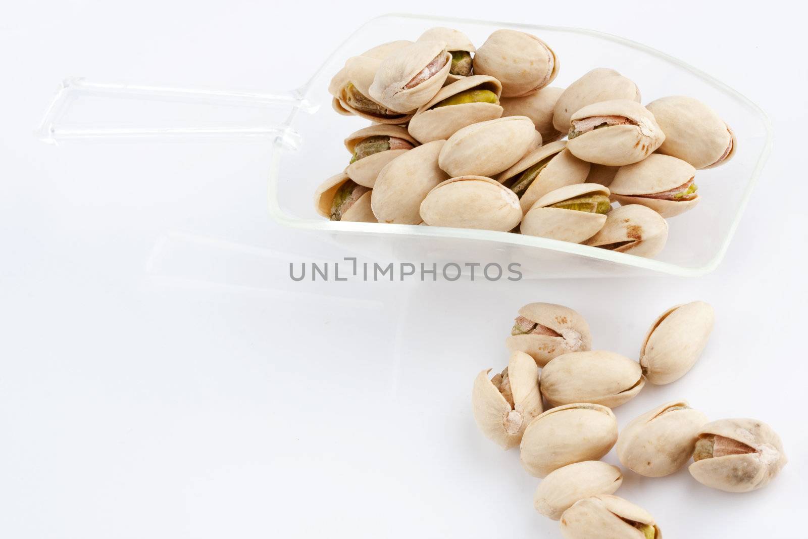 Scoop of roasted and salted pistachios by posterize