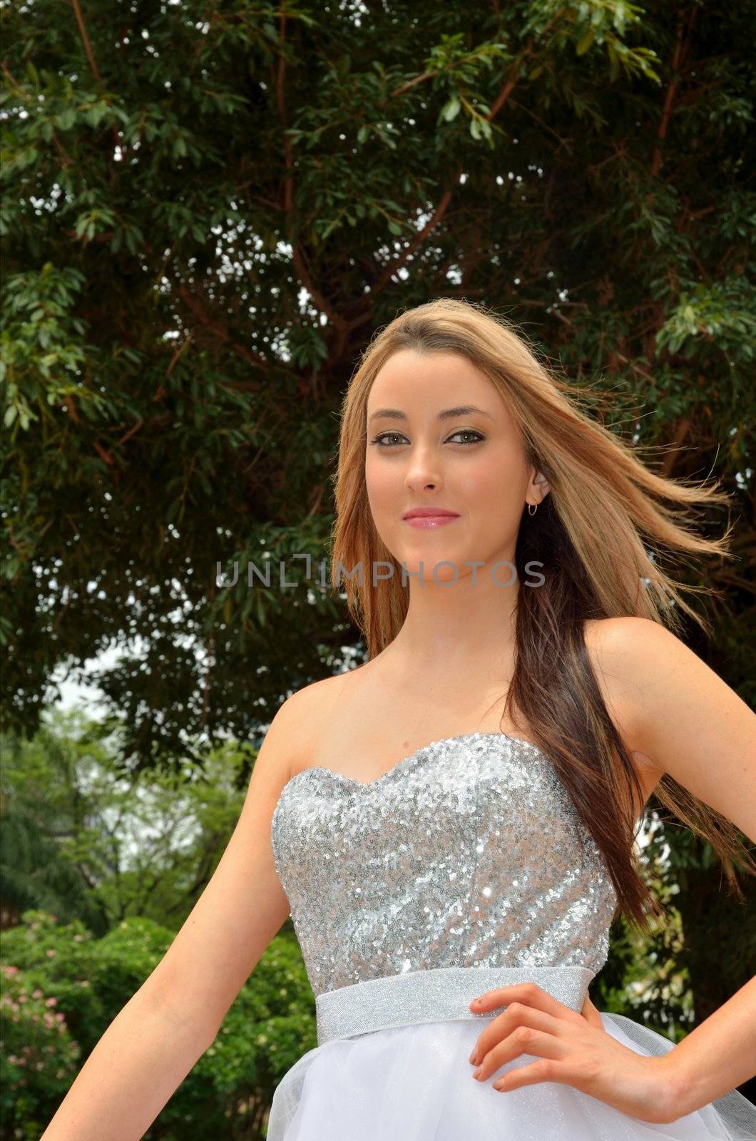 Attractive young lady standing tall in a city park.