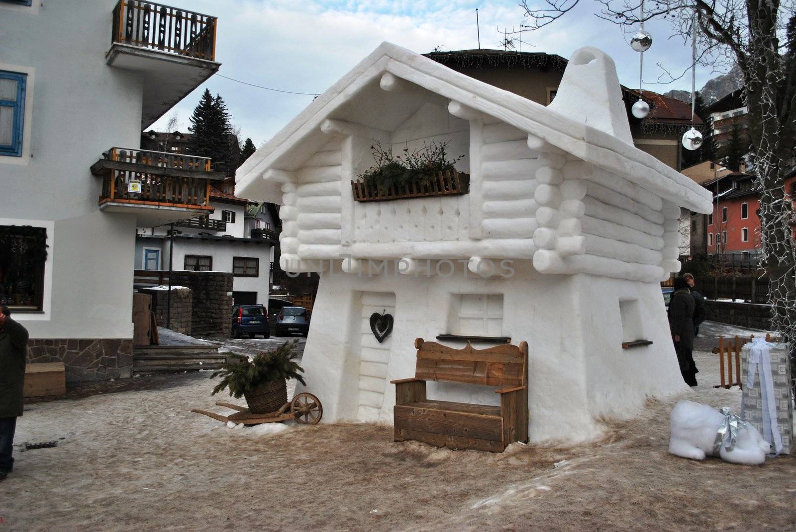 This is a sculpture made ​​entirely of snow made ​​in the old town of Moena, in Val di Fassa. Everything was embellished with the addition of some wood elements to create a real home