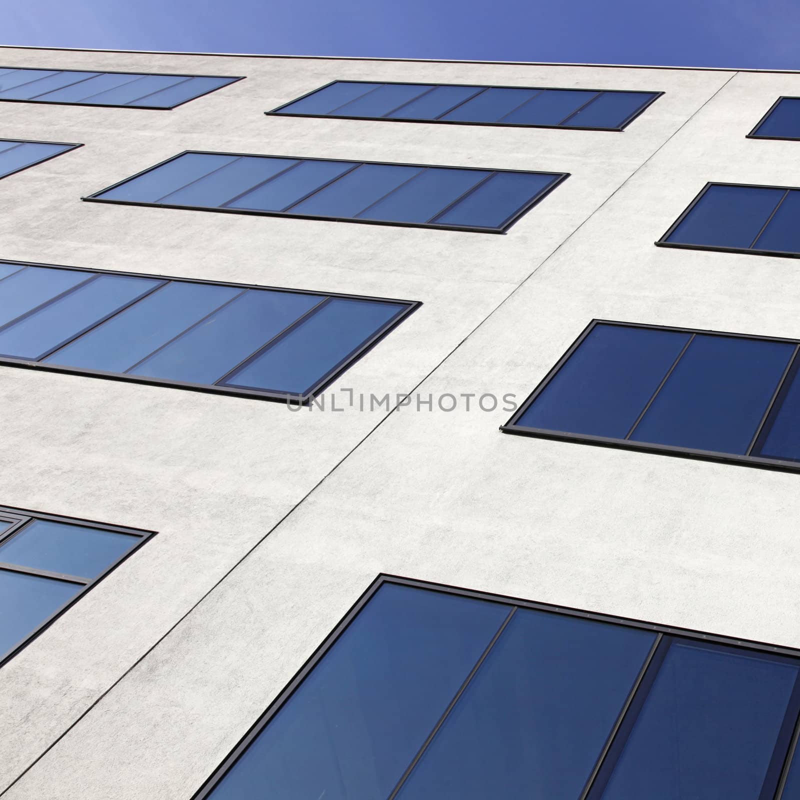 windows reflecting blue sky in modern facade