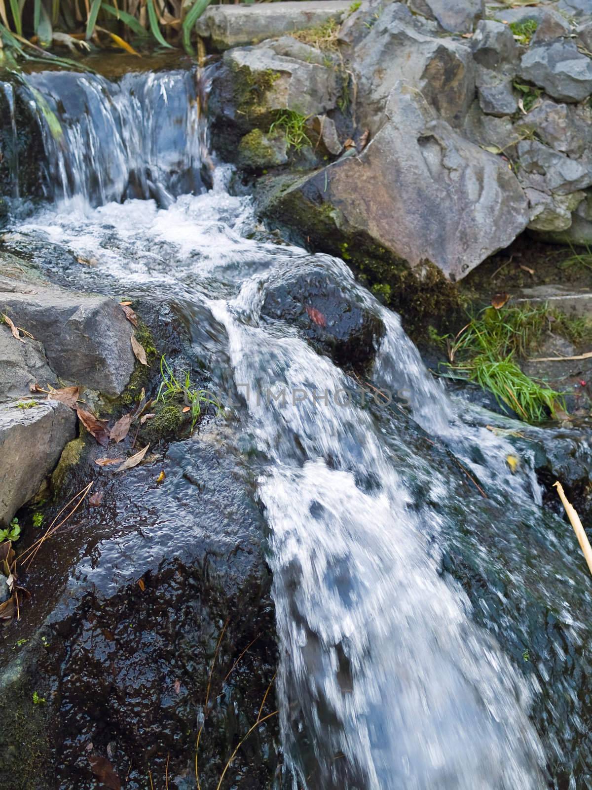 A Small Stream Flowing Over Some Rocks Makes a Waterfall