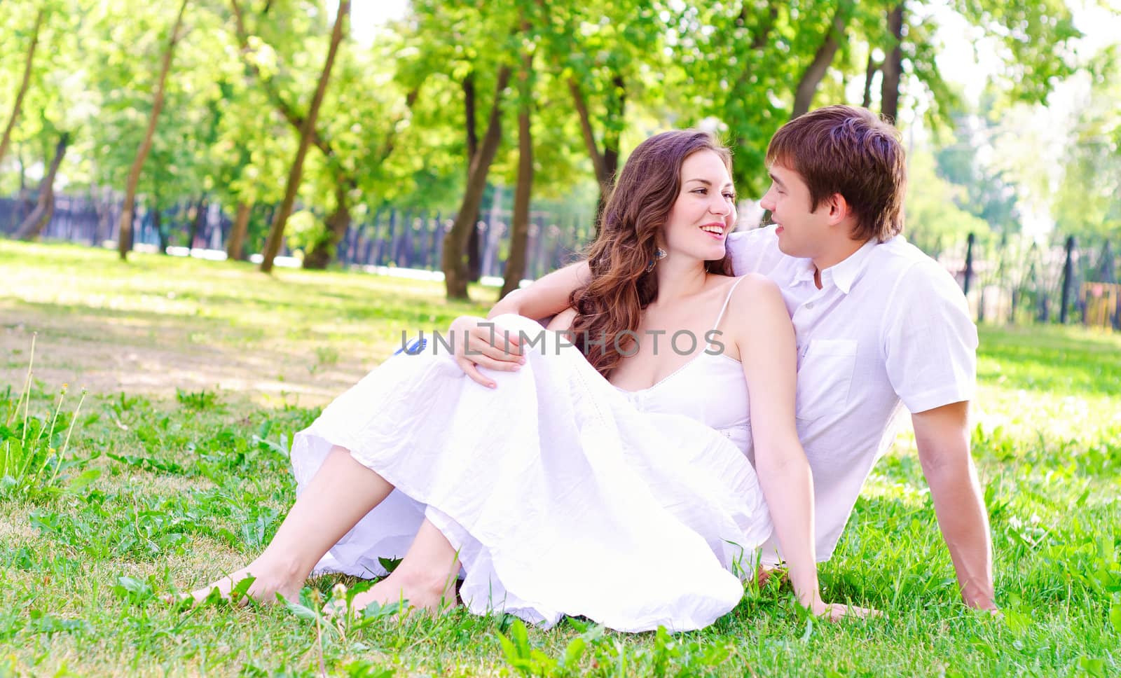 couple in the park sitting on the grass, have a good time together