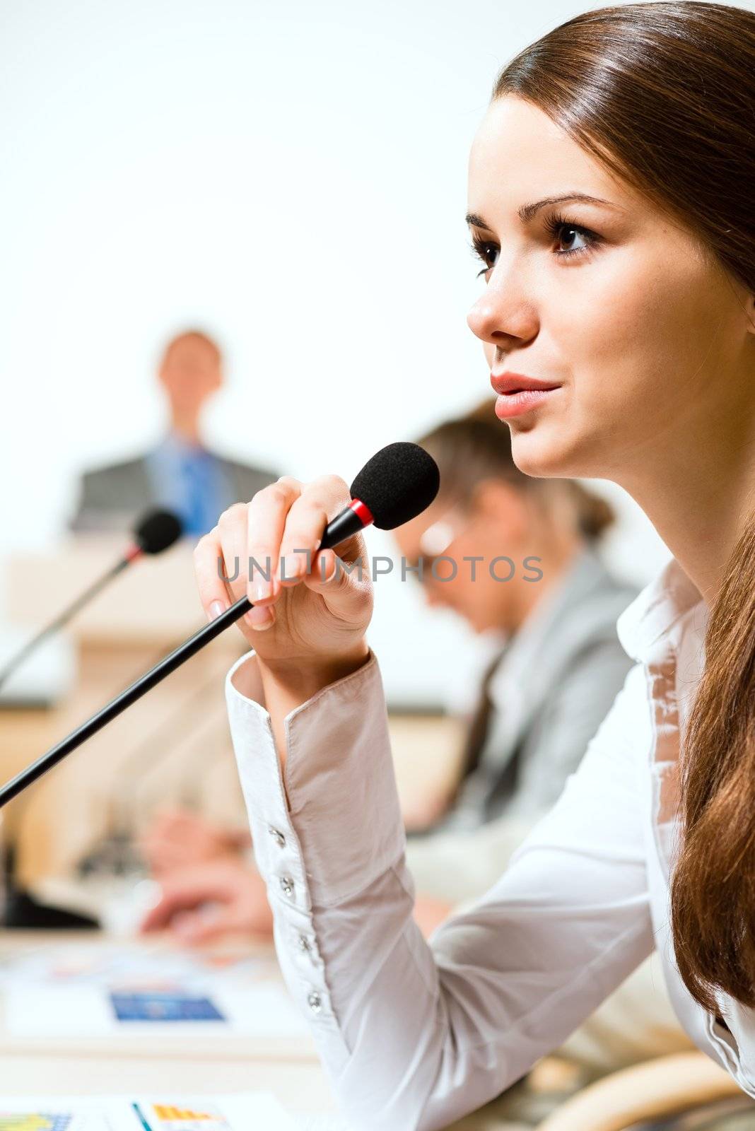 Business woman speaks into a microphone by adam121