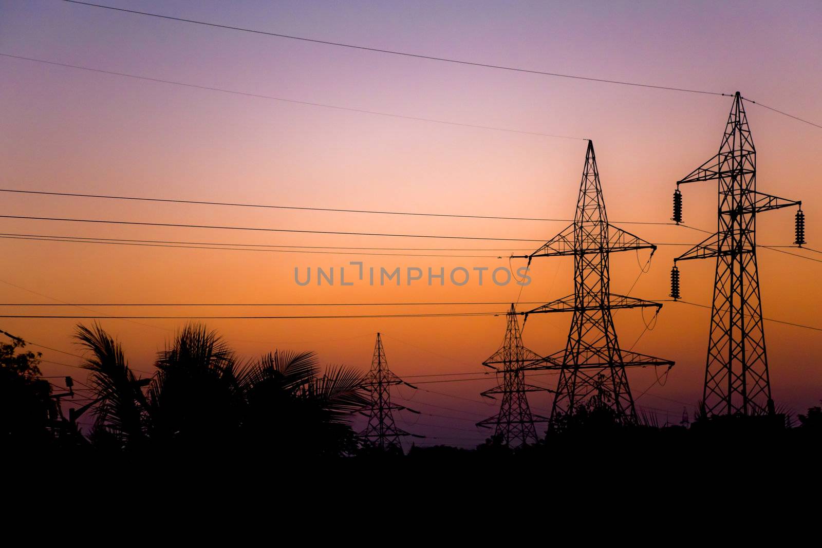 Generic landscape of national grid pylons and stanchions silhouetted at dawn. Shot taken 6 kilomteres from Bhavnagar, Gujarat India