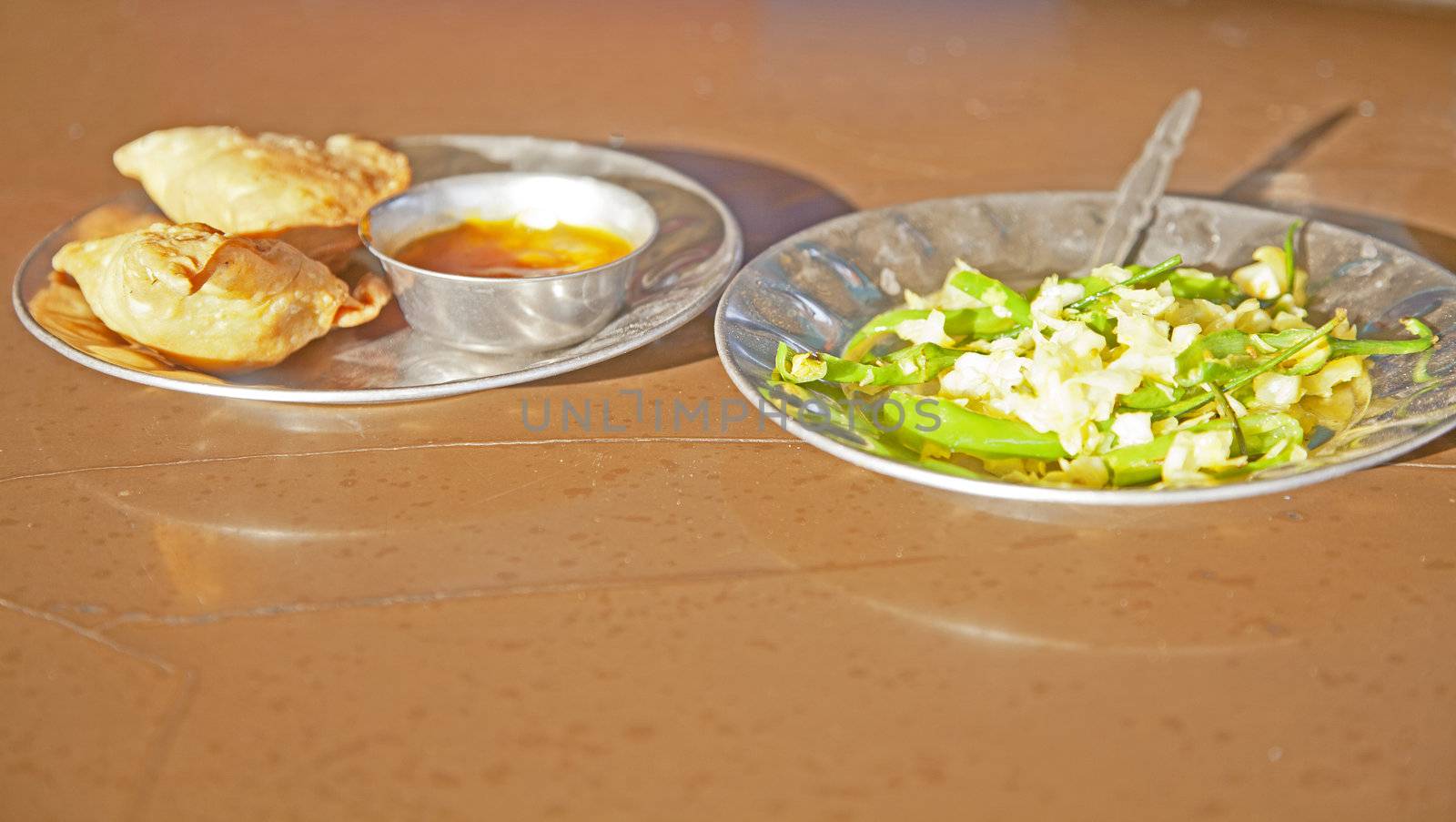 Shot taken at a Dhabha in Alunga Gujarat India. Breafast of samosas, chilli dip and stir fried white cabage with fresh green chillies