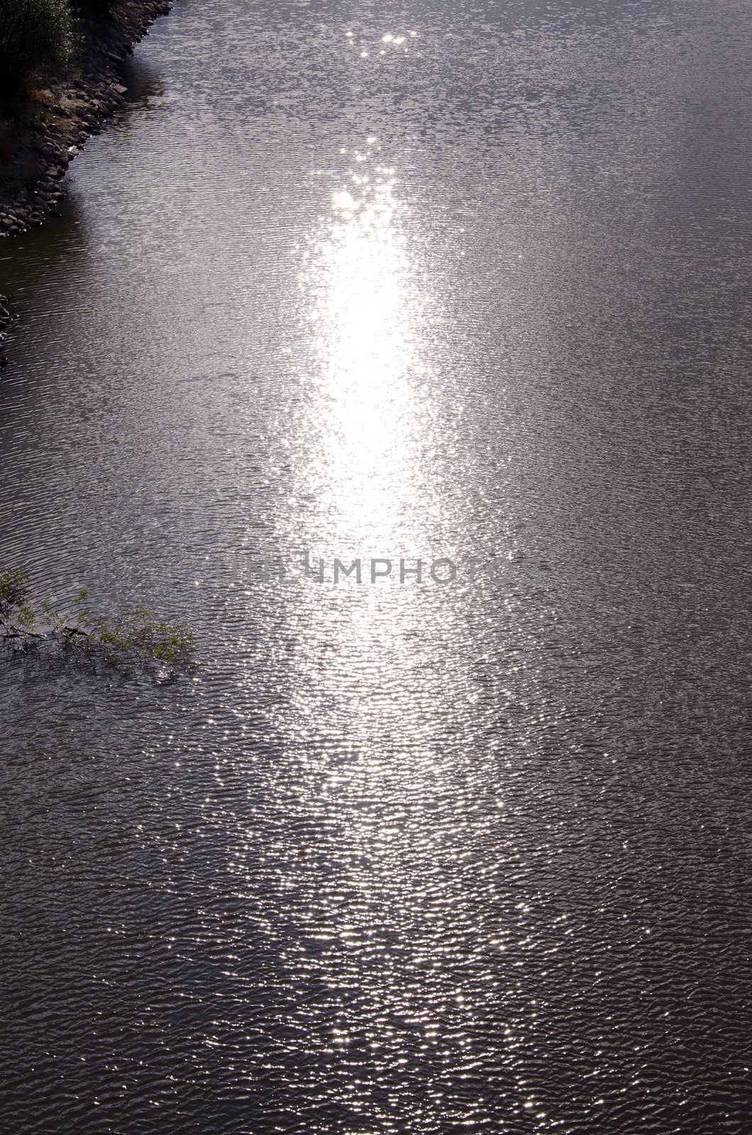 Background of ripple lake water and sun reflections. Natural nature backdrop.