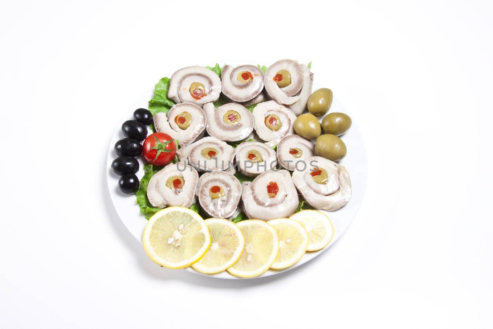 fish slices served with tomato and olives, and lemon