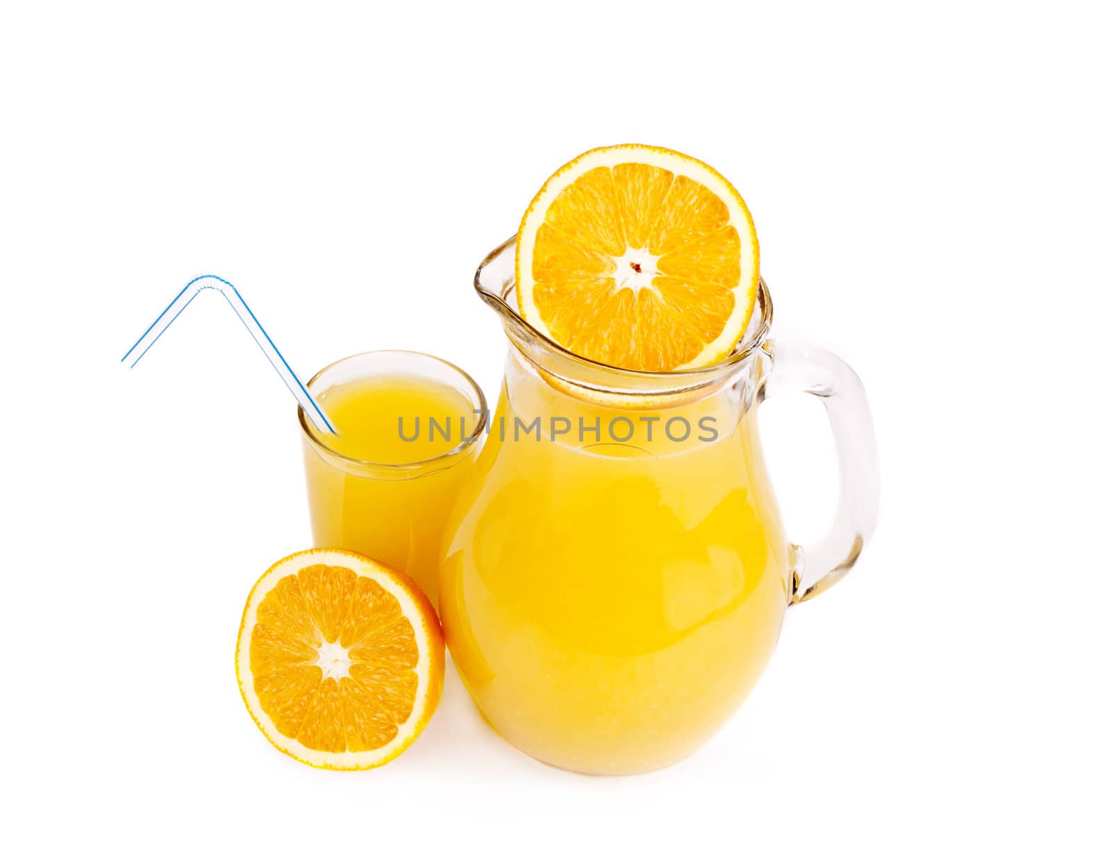 Orange juice in pitcher and oranges