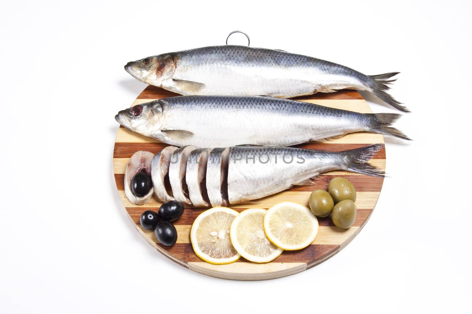 Fish with lemon and olive on wooden plate